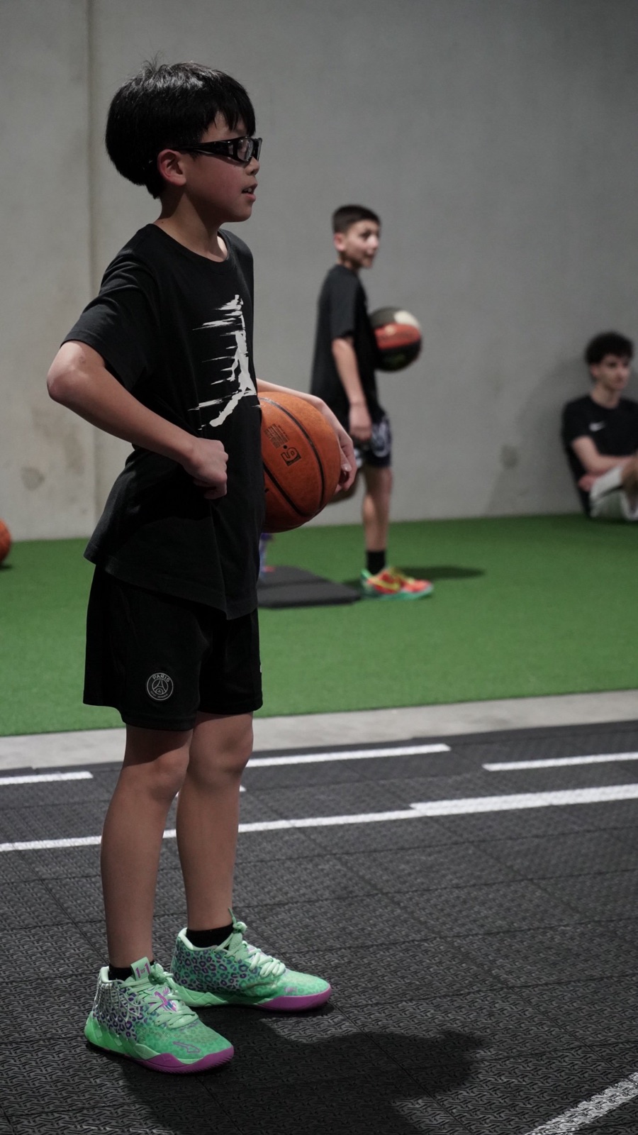 Young player holding a basketball during a Little Zeros session at From Zero
