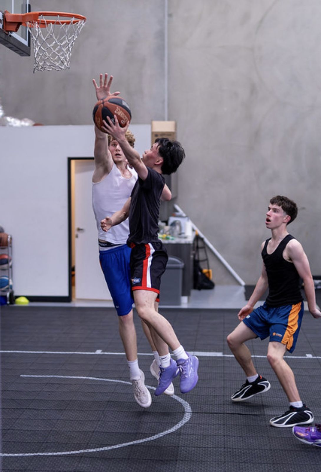 Player finishing over a defender at the rim