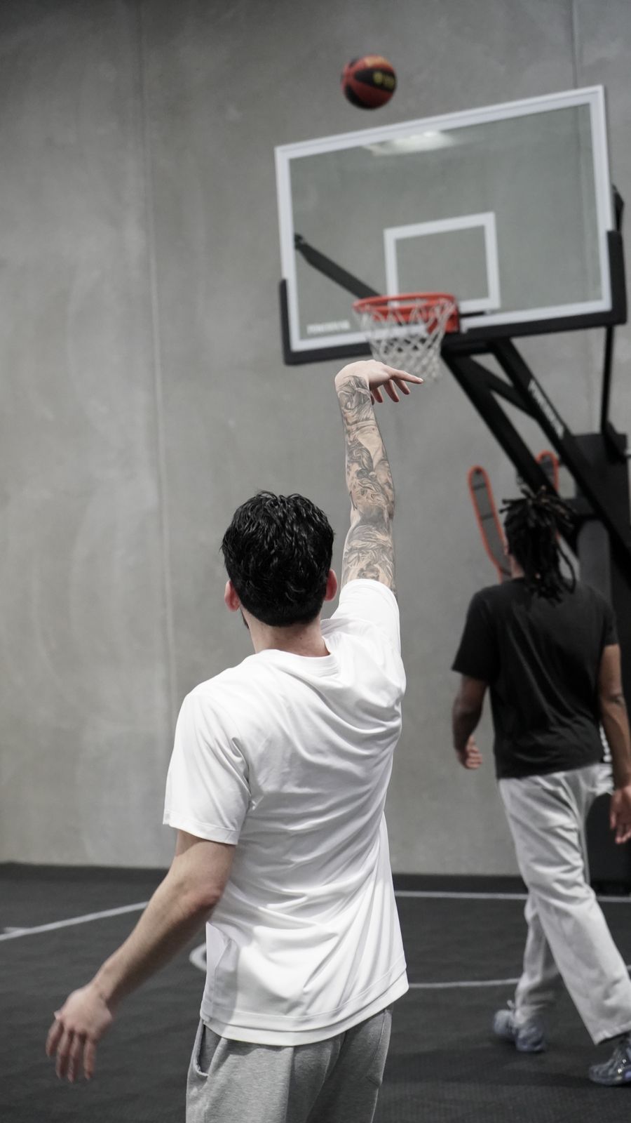 Player shooting a jump shot, ball on its way to the rim